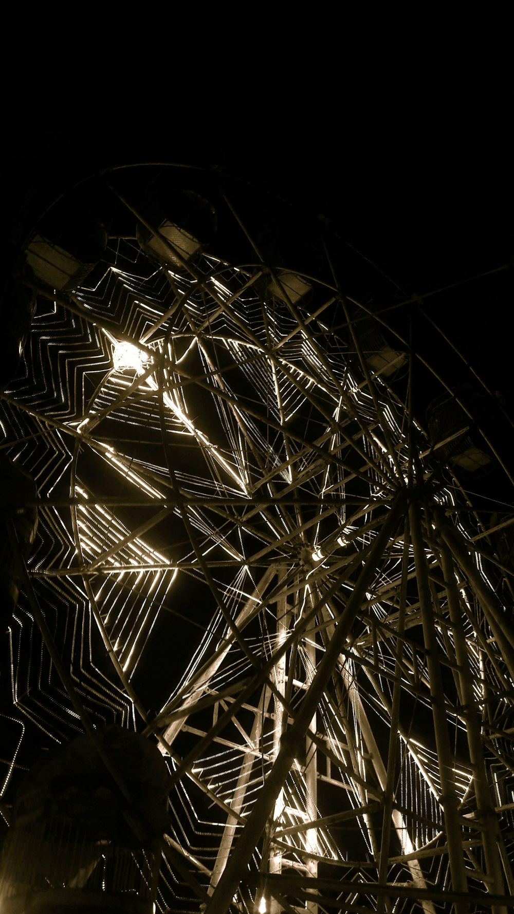 a ferris wheel lit up at night in the dark