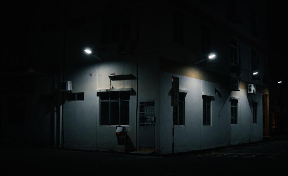 a dark street at night with a building lit up