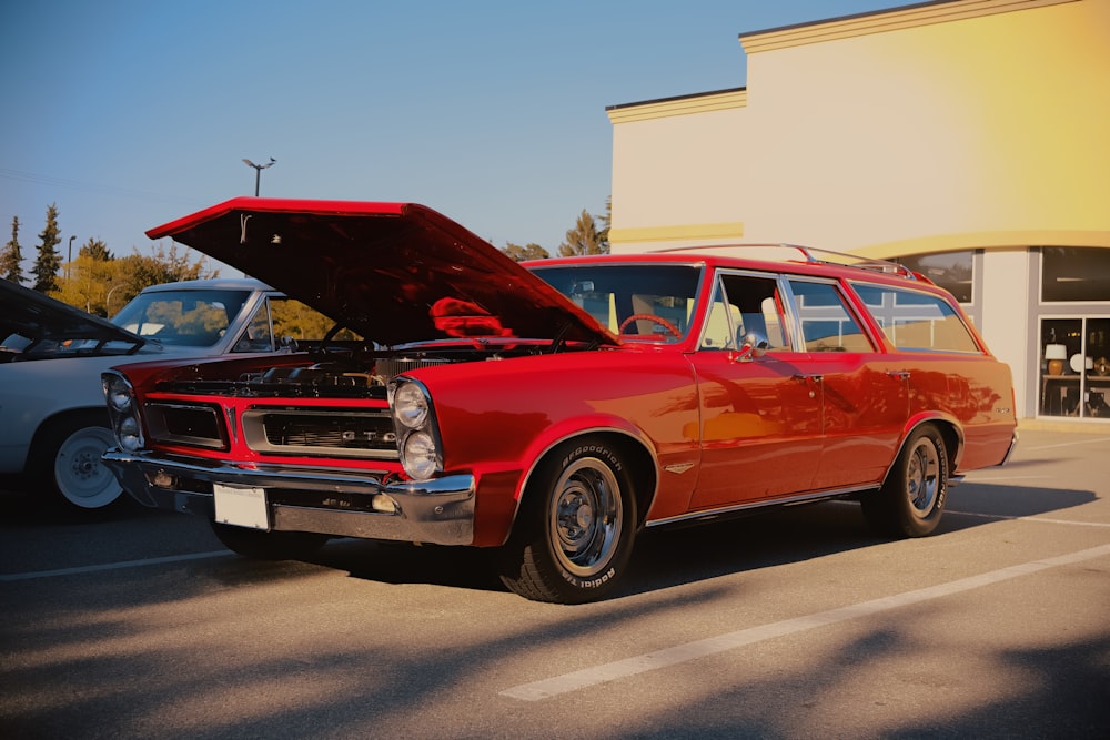 a red station wagon with its hood open