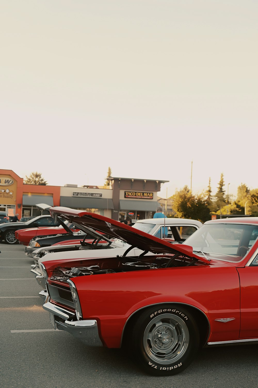 a red car parked in a parking lot next to other cars