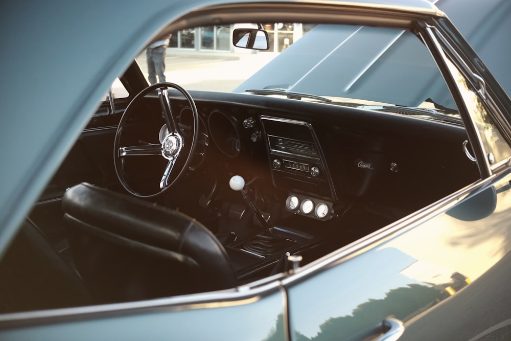 the interior of a classic car with the sun shining through the windshield