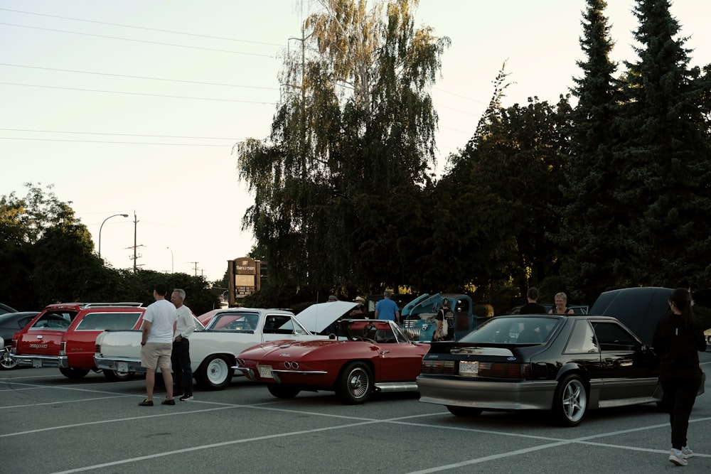 a parking lot full of cars and people standing around