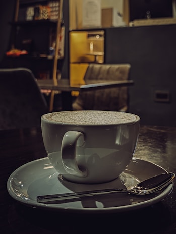 A steaming cup of rich Ceylon coffee served in a cozy brown and yellow-themed cafe setting.