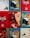 A collage of colorful illustrations featuring people interacting joyfully with Coca-Cola bottles. The artwork includes diverse figures laughing and enjoying each other's company, set against vibrant red, blue, and green backgrounds. Some panels have Coca-Cola branding and QR codes.