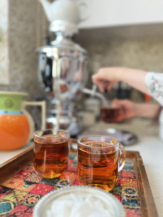 A close-up of steaming Persian tea served in elegant glasses.