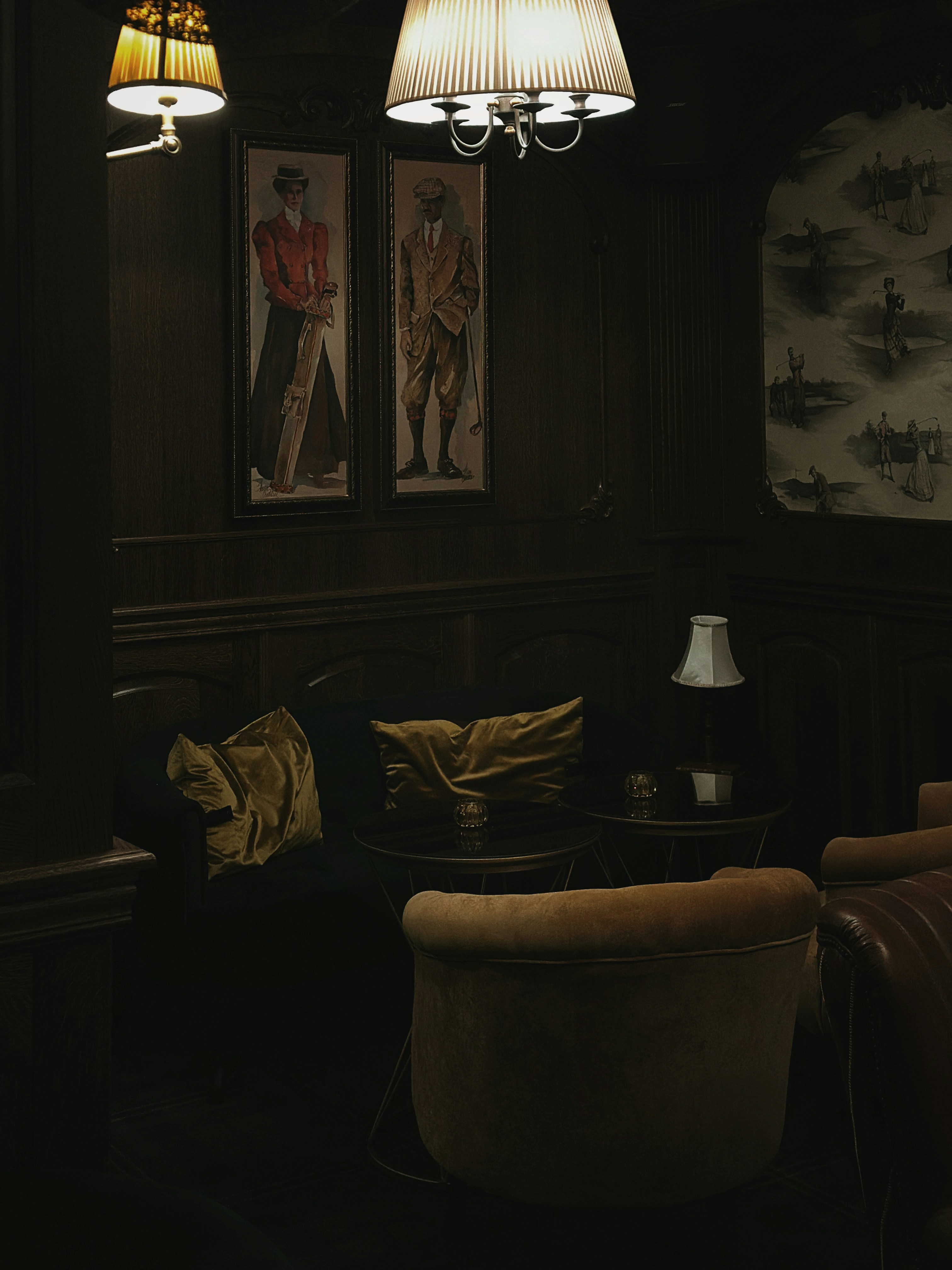 a dimly lit living room with two paintings on the wall