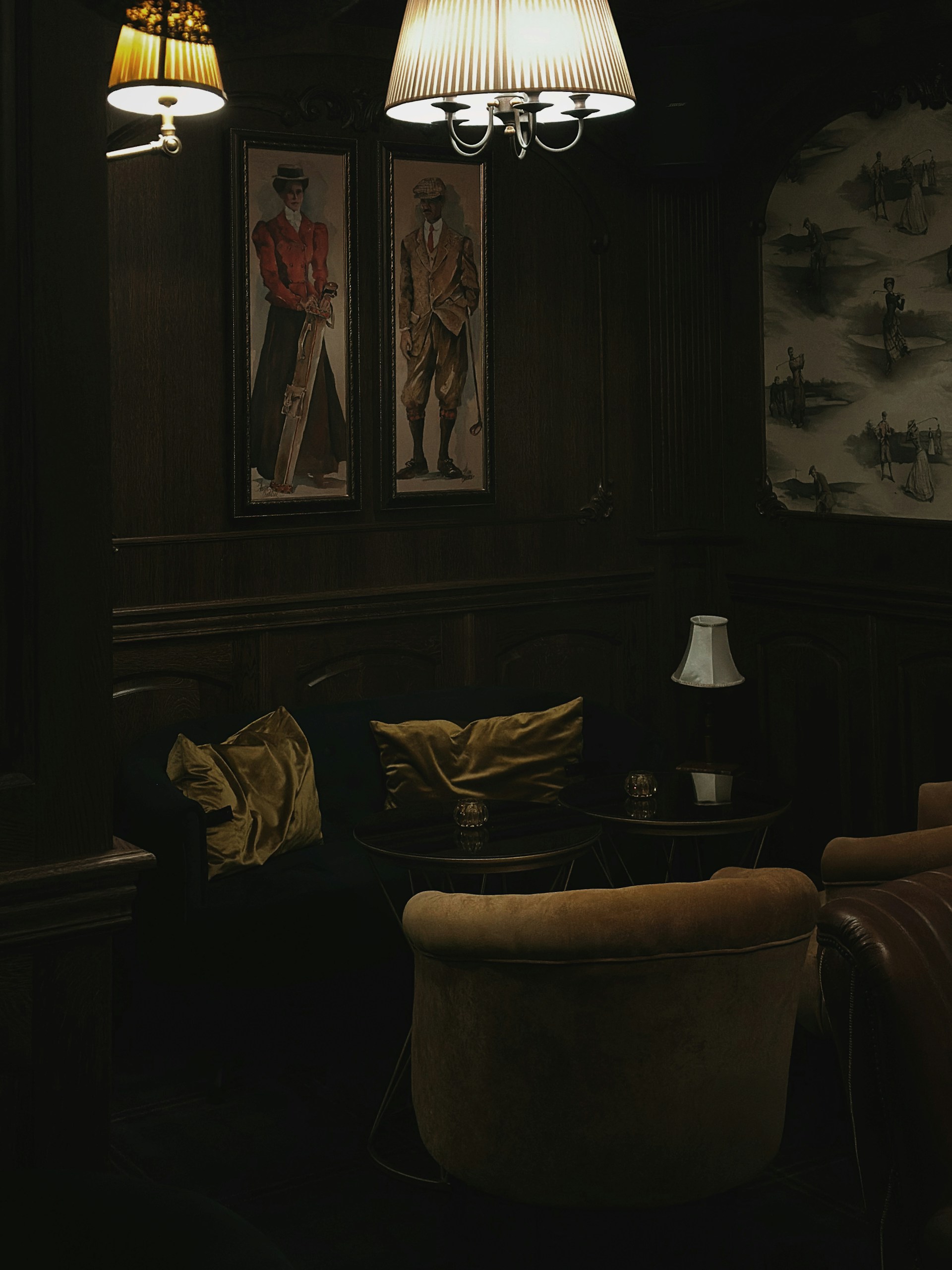 a dimly lit living room with two paintings on the wall