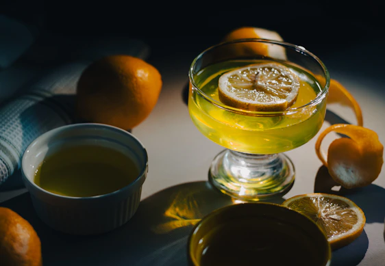 A vibrant bowl of lemon gelato garnished with fresh lemon slices and mint leaves on a rustic wooden table.