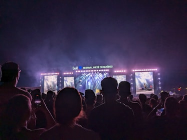 An energetic live concert under the Global 100 Radio Coalition banner with a cheering crowd.