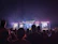 Crowd cheering wildly under vibrant stage lights at a Dubai concert.