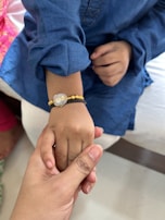 A close-up of a colorful awareness bracelet with the EA alliance logo worn by a child.