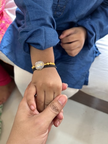 Close-up of a child's hand wearing a delicate, charming bracelet from the children's accessory collection.