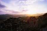 The Great Wall stretching over rugged hills at sunrise, the stones glowing warm as the day begins.