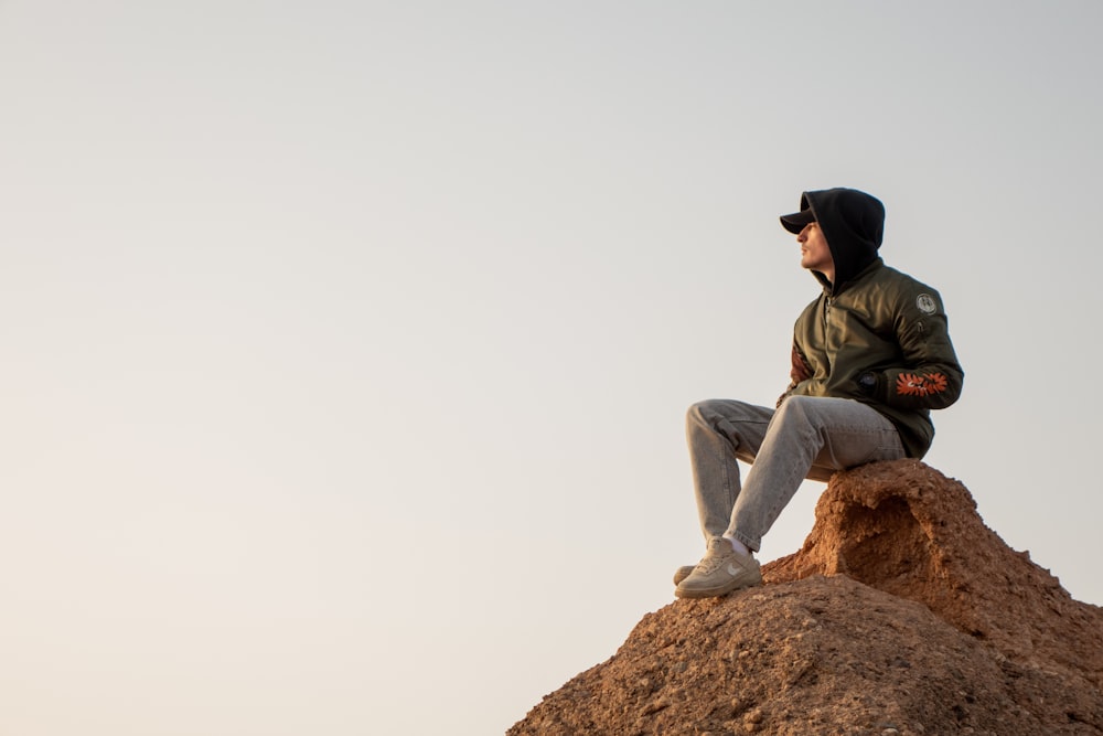 a man sitting on top of a pile of dirt