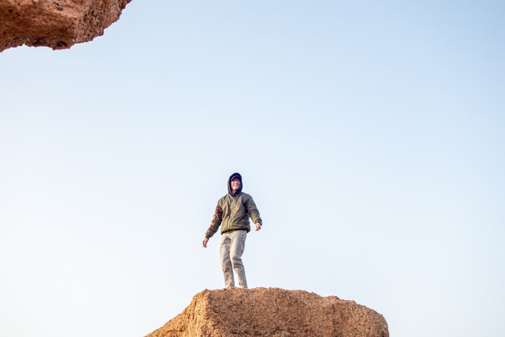 a man standing on top of a large rock