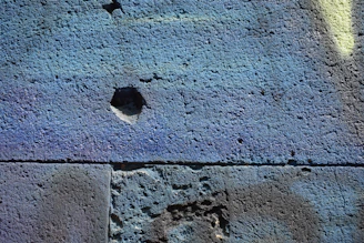 A close-up of hands applying smooth microcement on a wall, showcasing texture and detail.