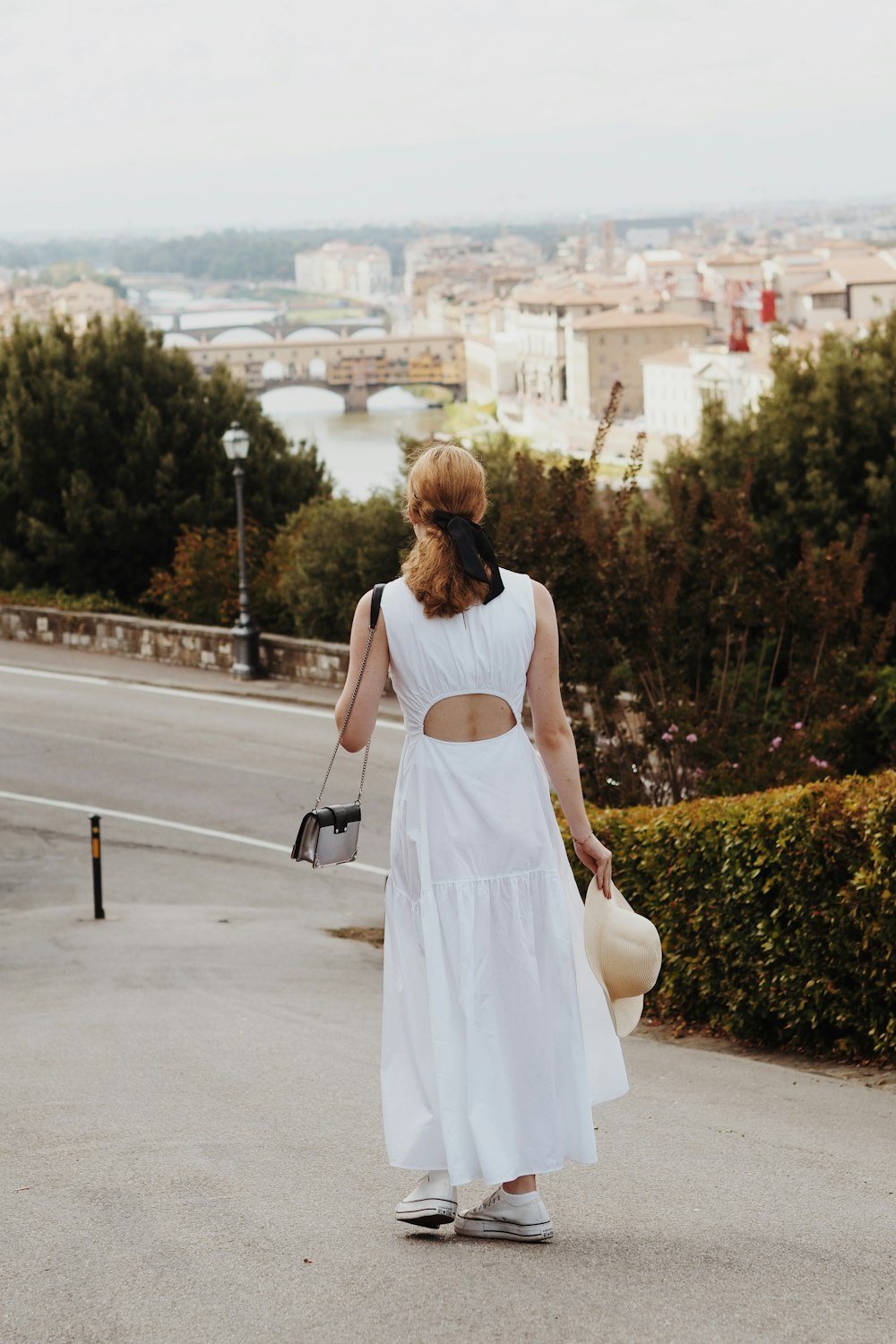 a woman in a white dress walking down a street