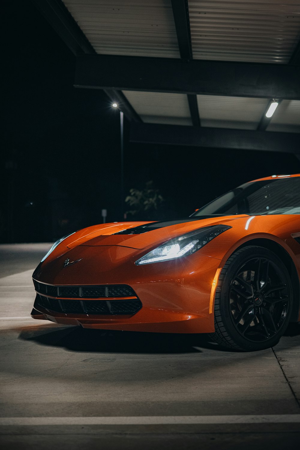 an orange sports car parked in a parking garage