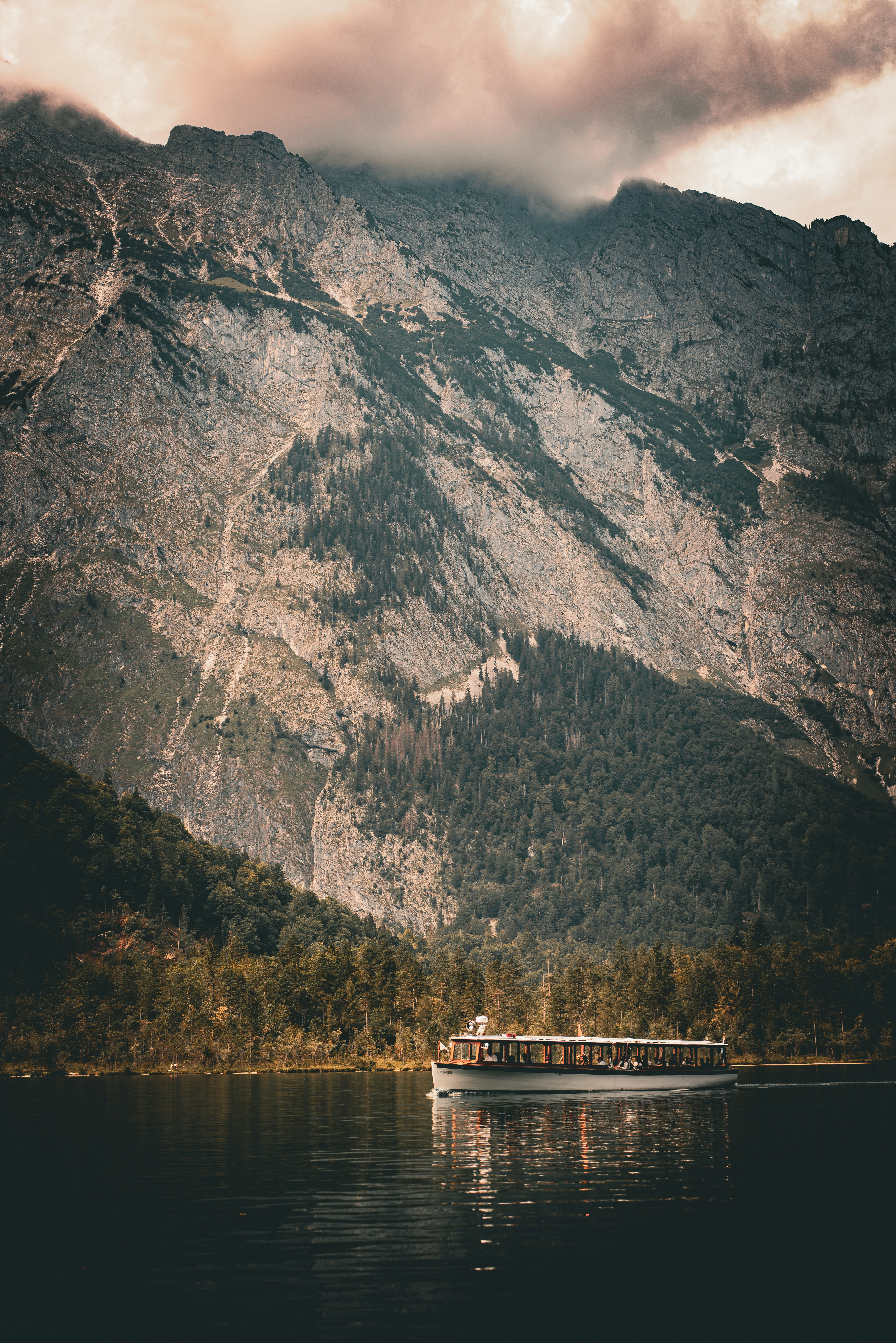 a boat floating on top of a lake next to a mountain