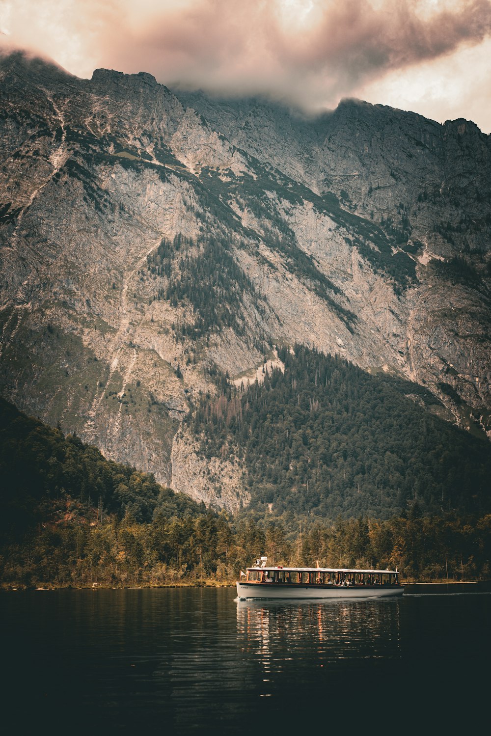 山の隣の湖の上に浮かぶボート