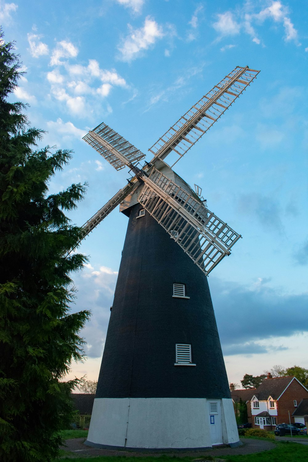 a large windmill sitting next to a tree