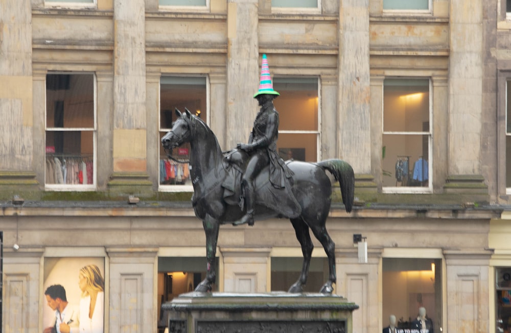 a statue of a man on a horse in front of a building