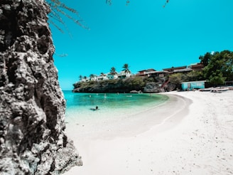 A family relaxing on a pristine white sandy beach with turquoise waters in the background.