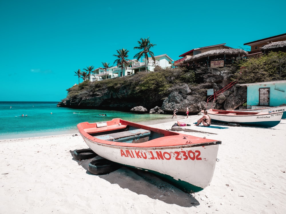 two boats on a beach with a house in the background