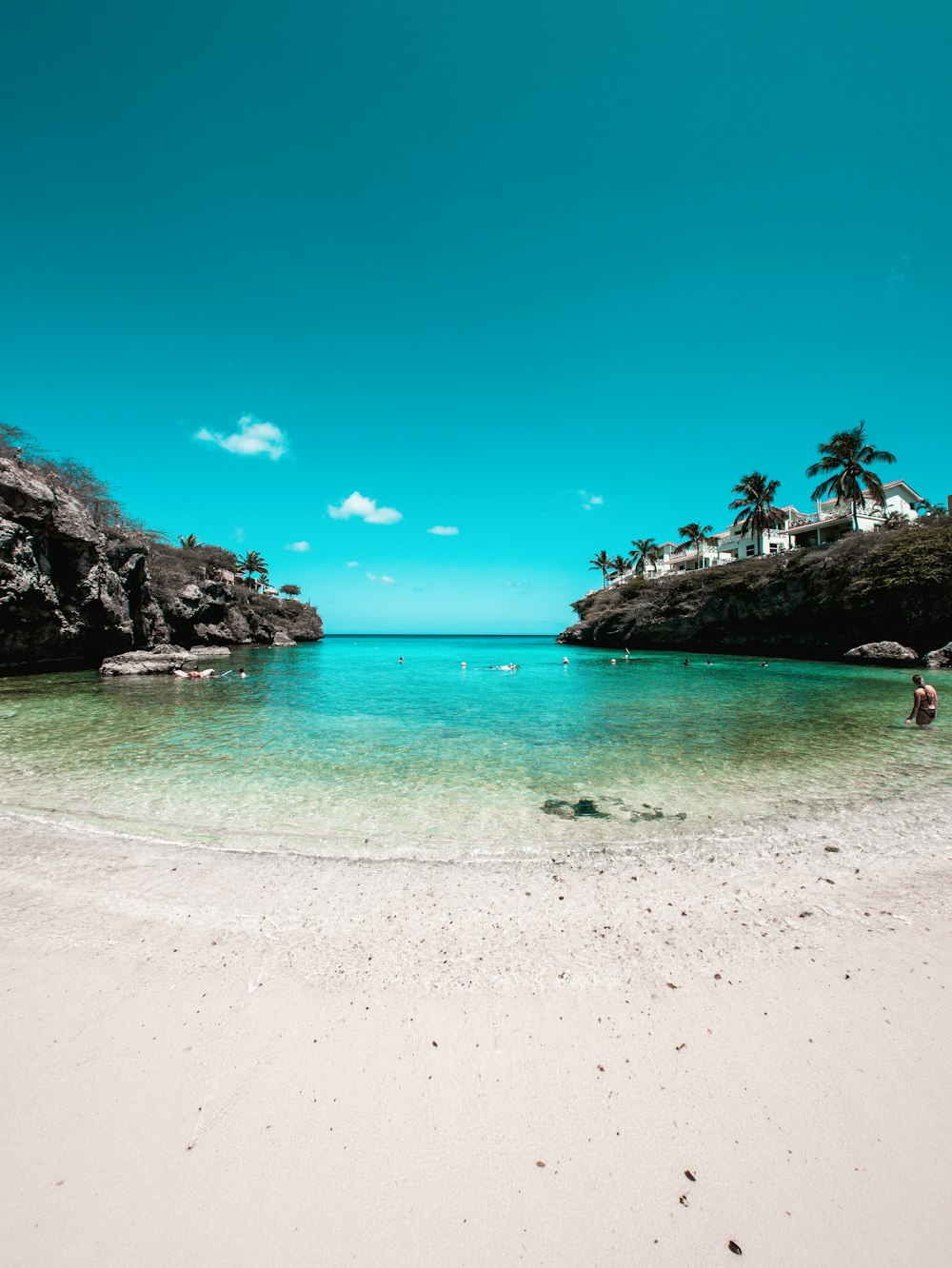 a person standing on a beach next to a body of water