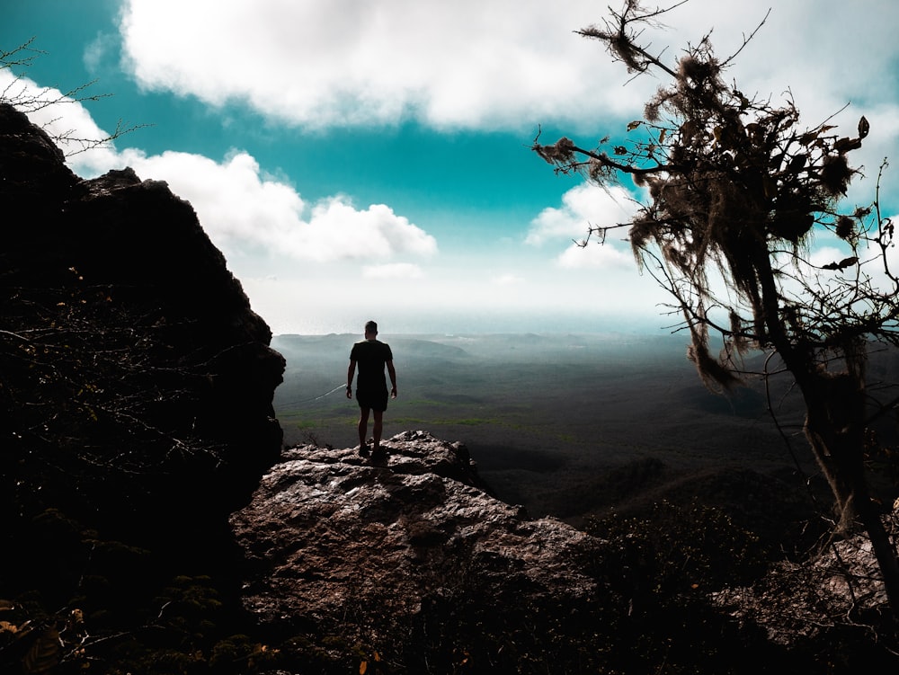 a man standing on top of a rocky cliff