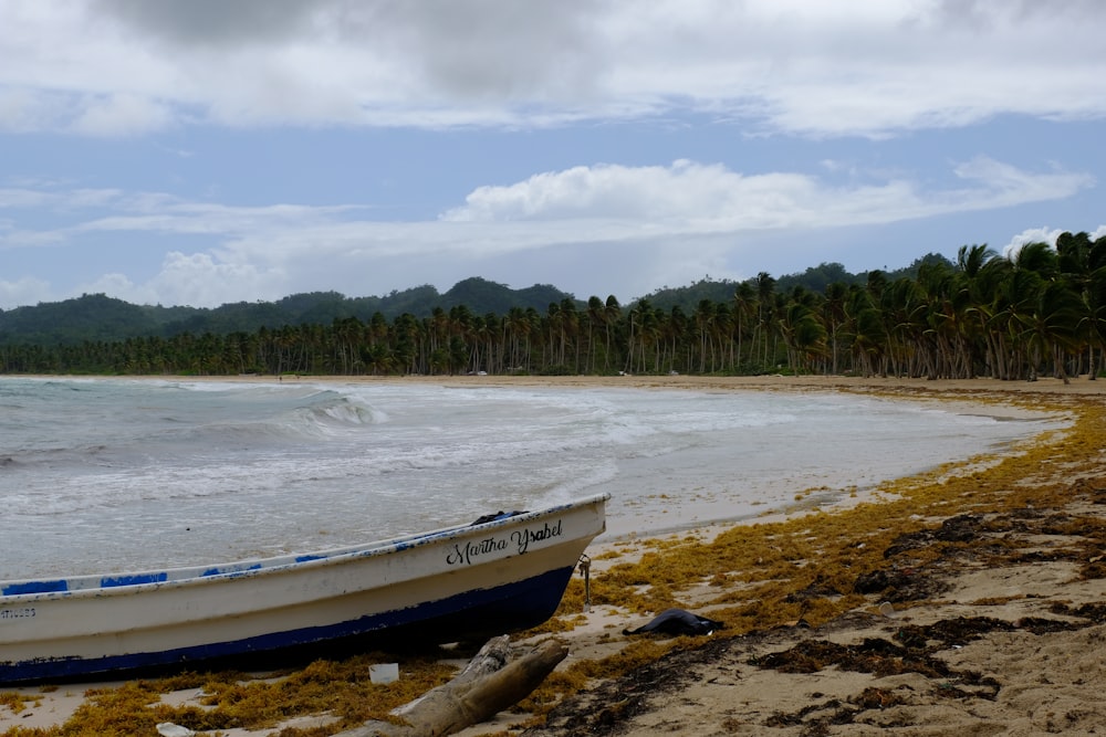 a boat sitting on top of a sandy beach