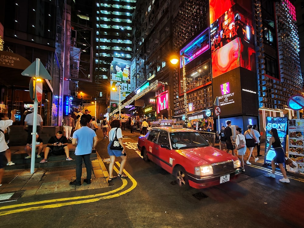 a busy city street at night with people and cars