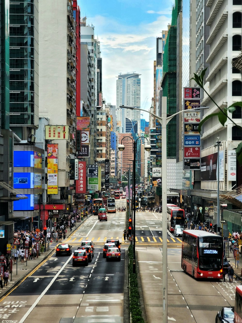 a city street filled with lots of traffic next to tall buildings