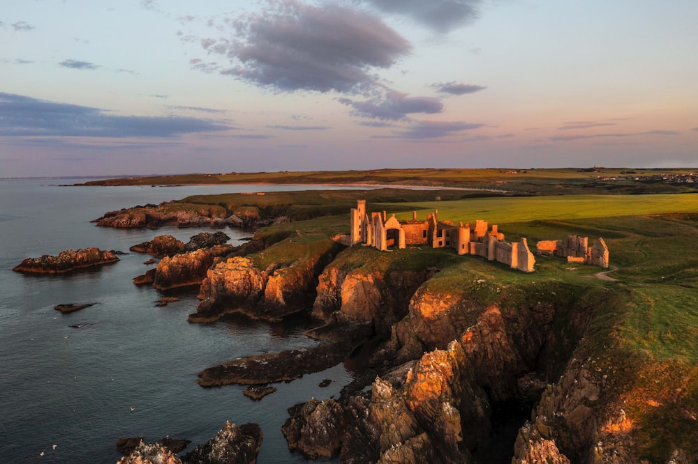 an aerial view of a castle on a cliff overlooking a body of water