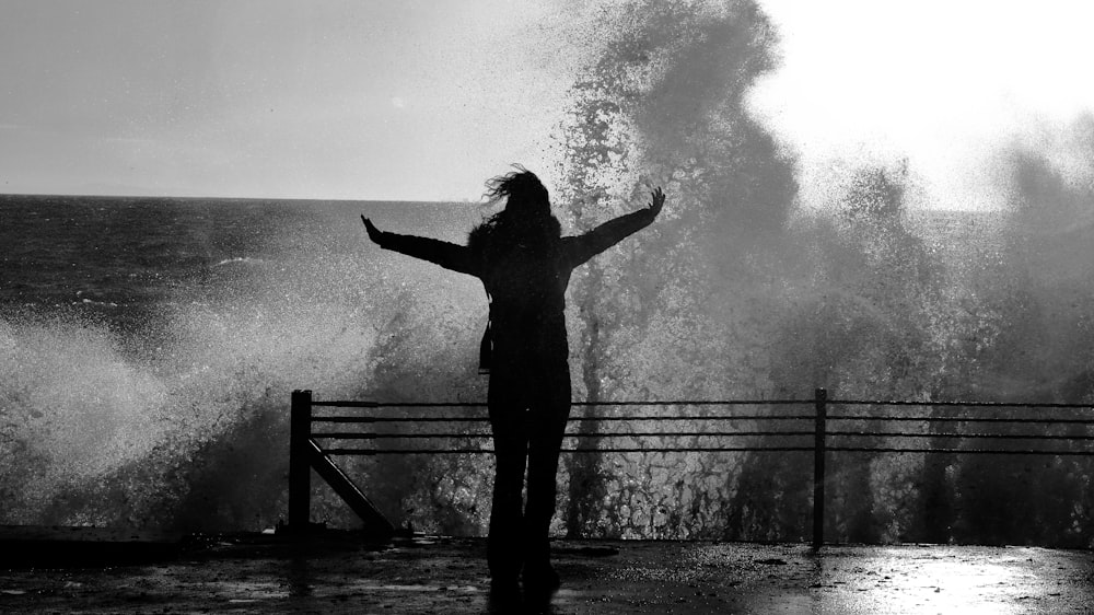 a person standing in front of a large wave
