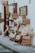 A rustic Italian bakery display on a street, featuring various types of bread and baked goods. Wooden signs with text in Italian advertise focaccia, panini, and other items made with sourdough. Large loaves and bags of bread are artfully arranged on shelves outside the shop, creating an inviting and traditional atmosphere.