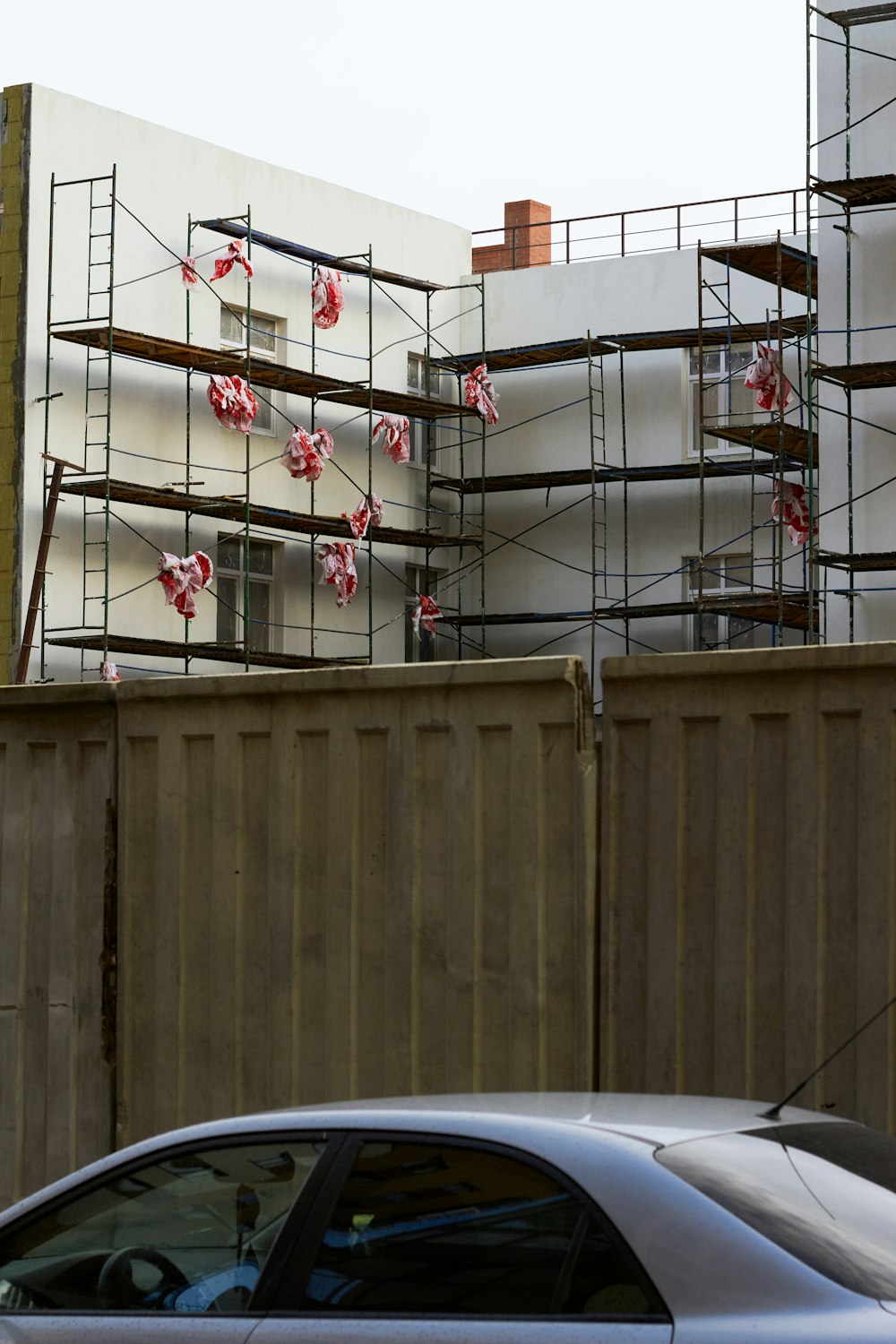 a car parked in front of a building with scaffolding