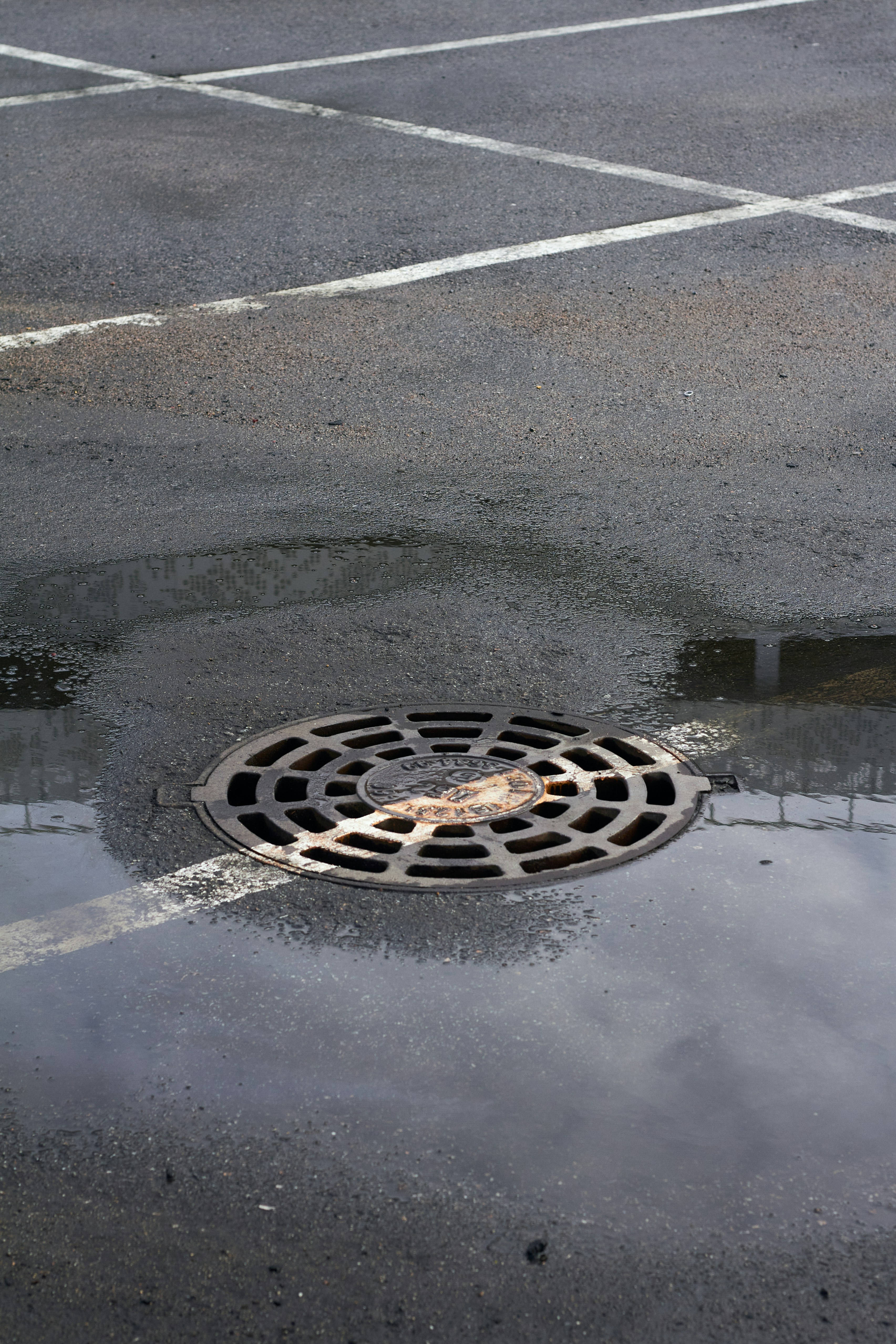 a manhole cover in the middle of a parking lot