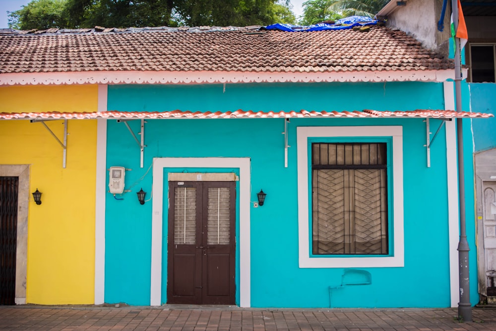 a blue building with a brown door and windows