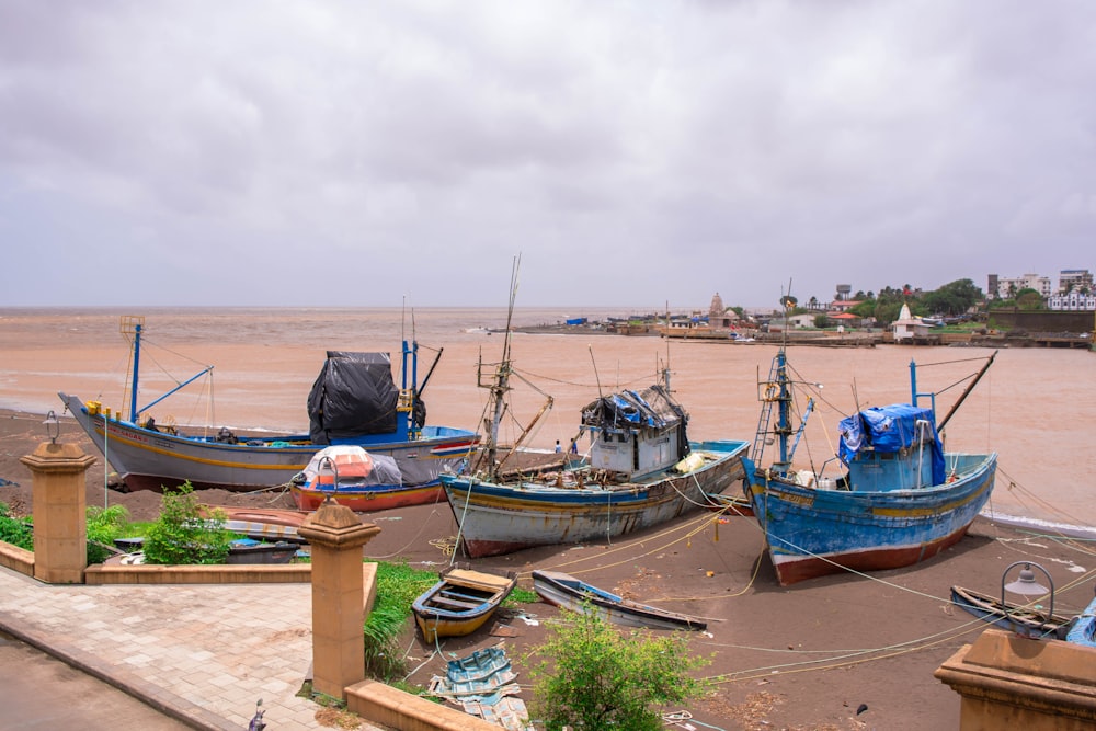 a group of boats sitting on top of a sandy beach