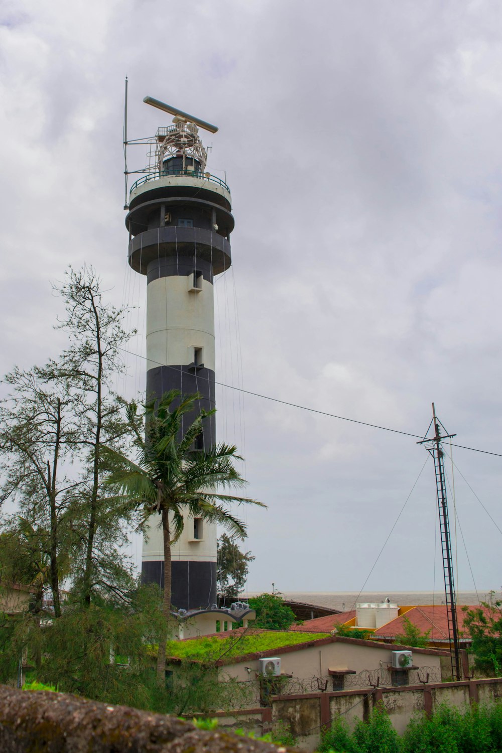 a tall white and black tower with a sky background