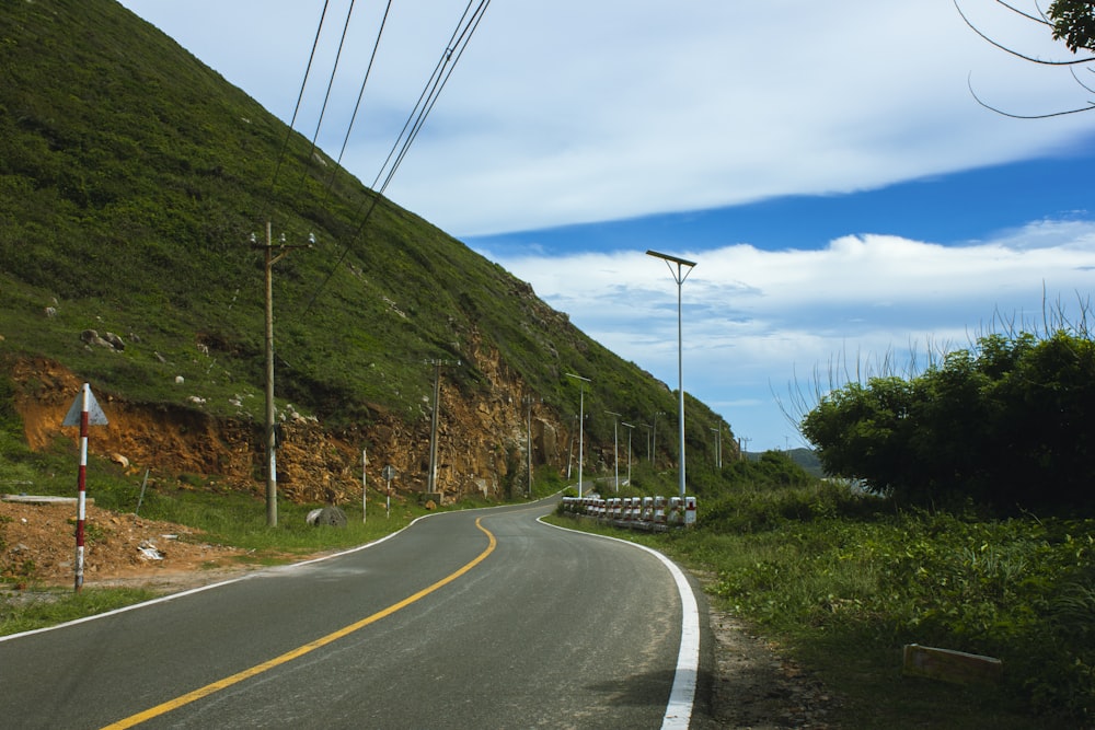 an empty road with a hill in the background