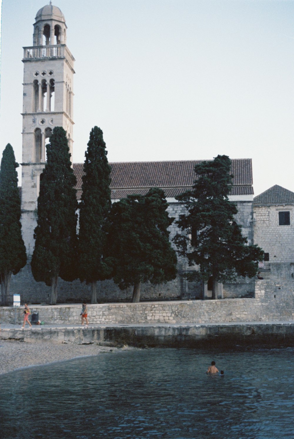 a building with a clock tower next to a body of water