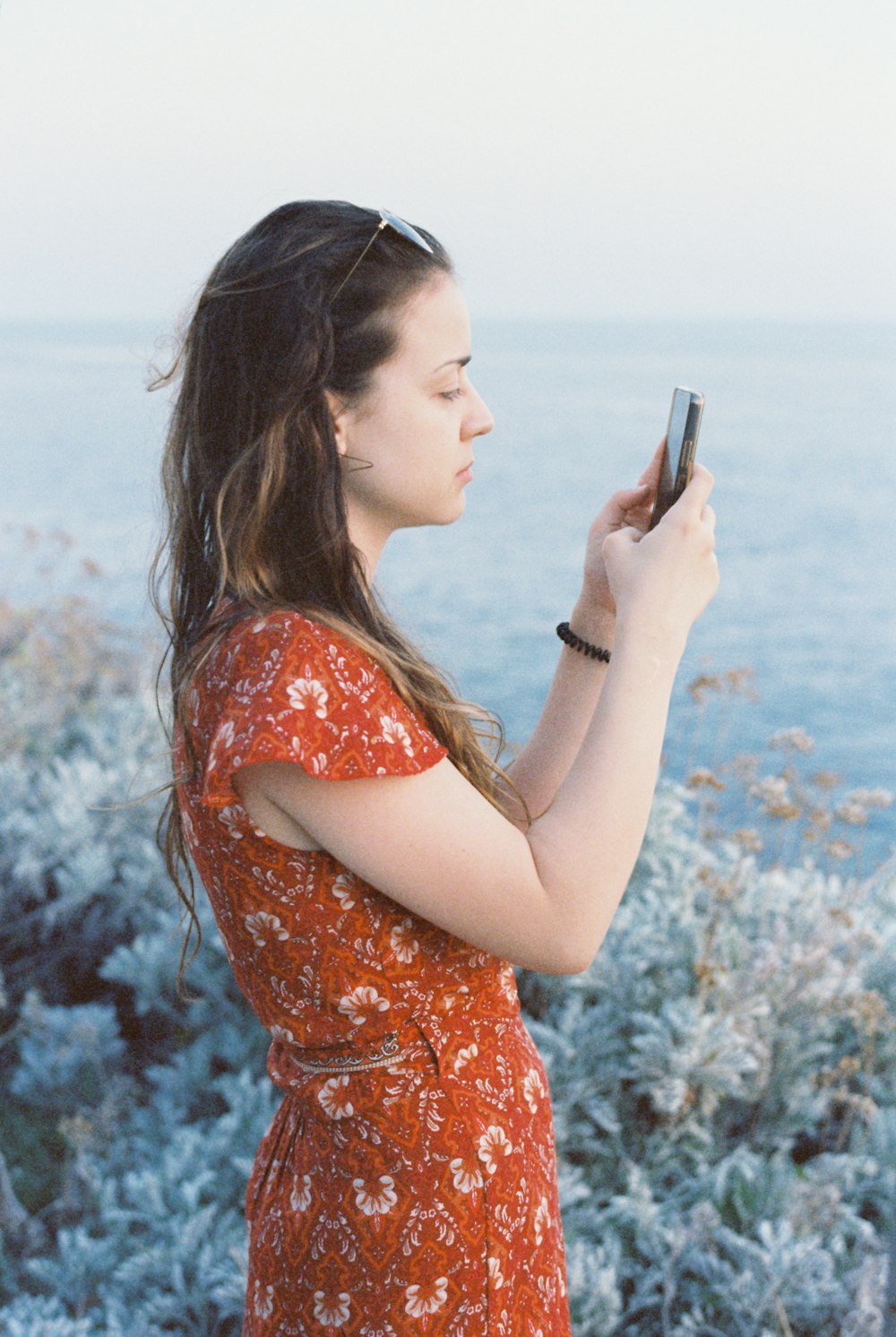 a woman in a red dress looking at her cell phone