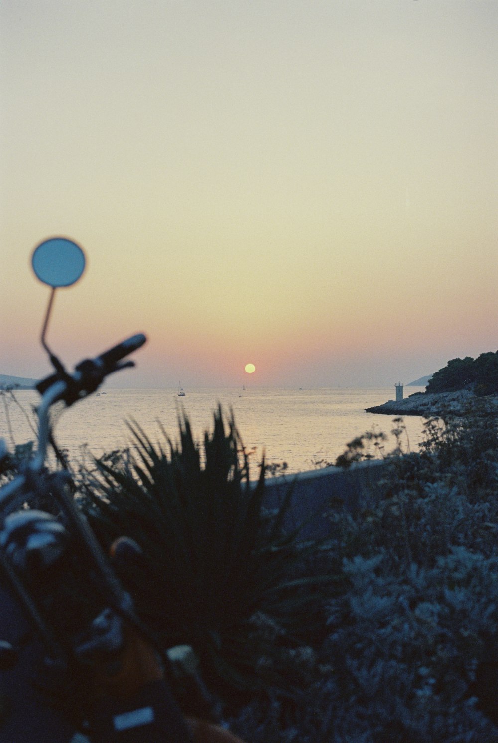 a motorcycle parked on the side of a road near the ocean