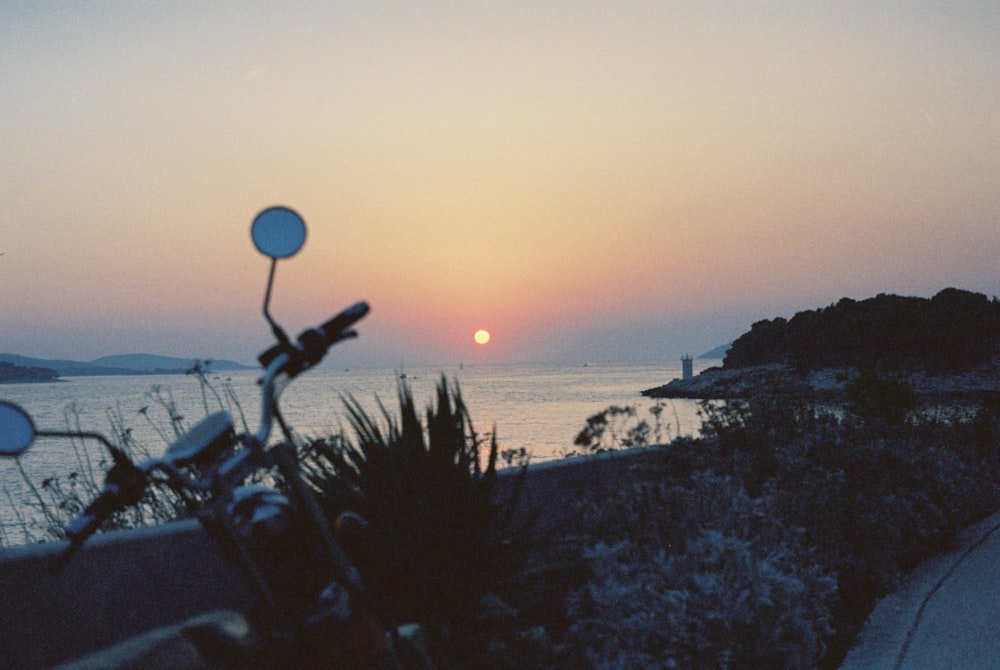 a motorcycle parked on the side of a road near the ocean