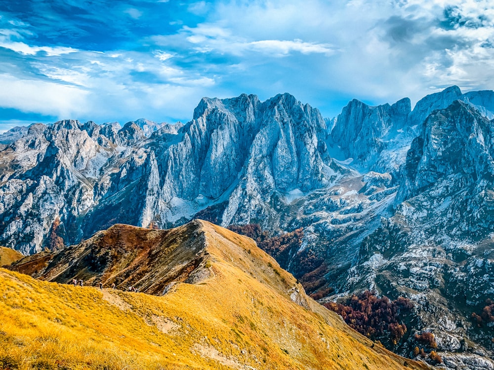 a view of a mountain range from the top of a hill