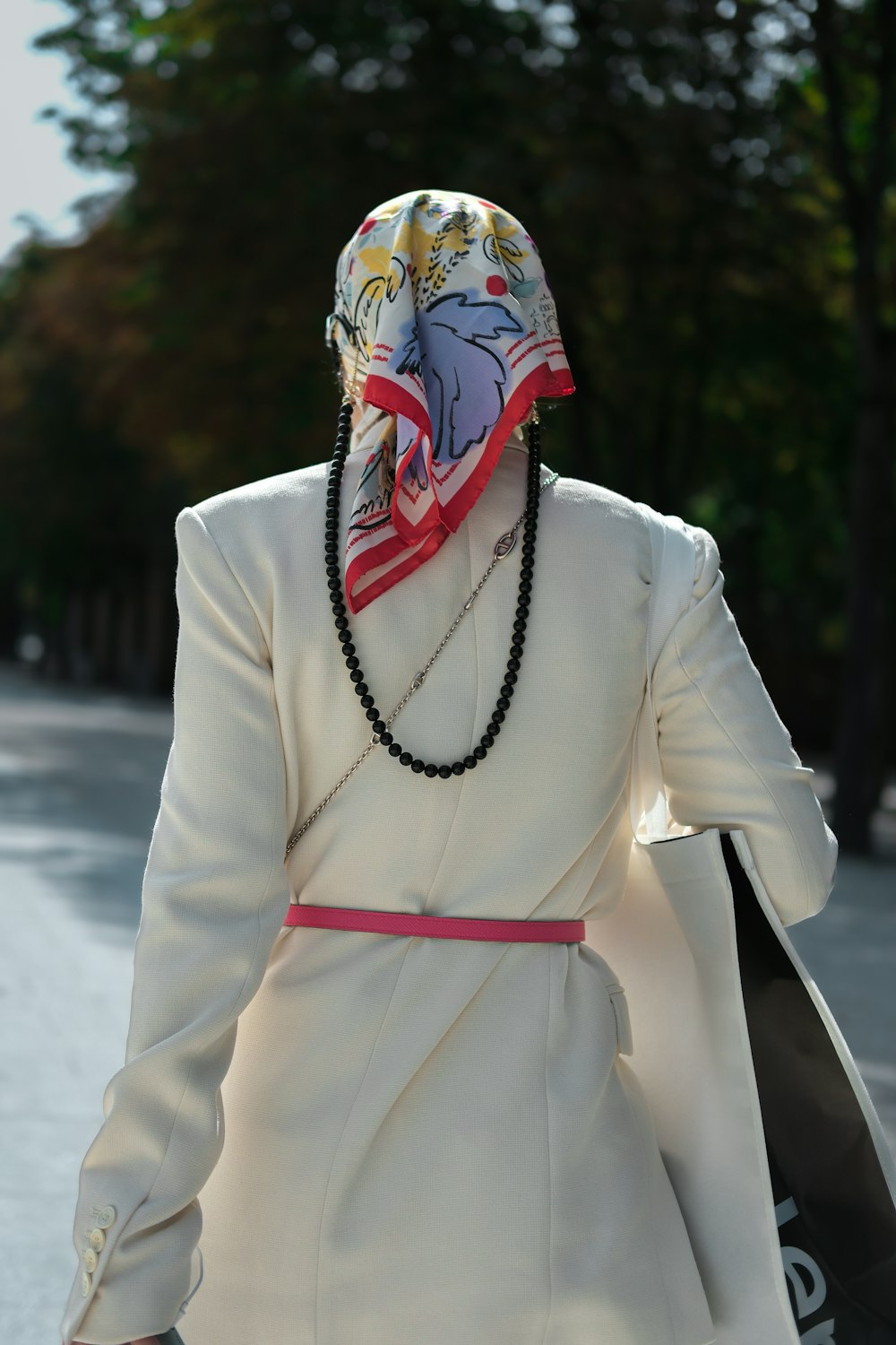 a woman wearing a white coat and a red and white scarf