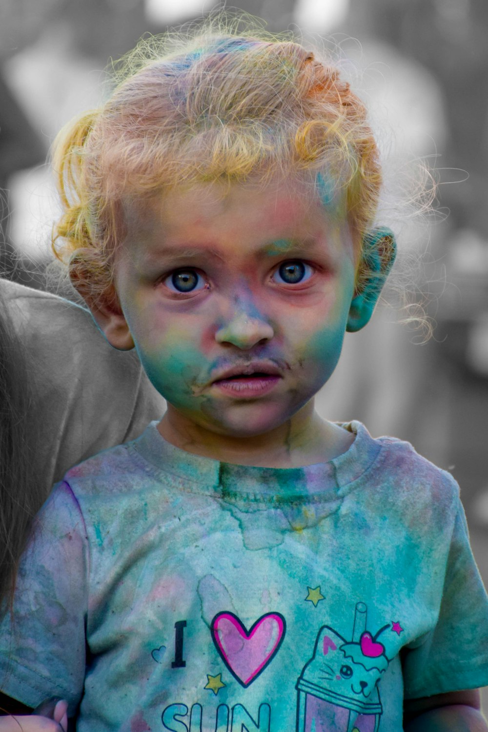 a little girl with blue and green paint on her face