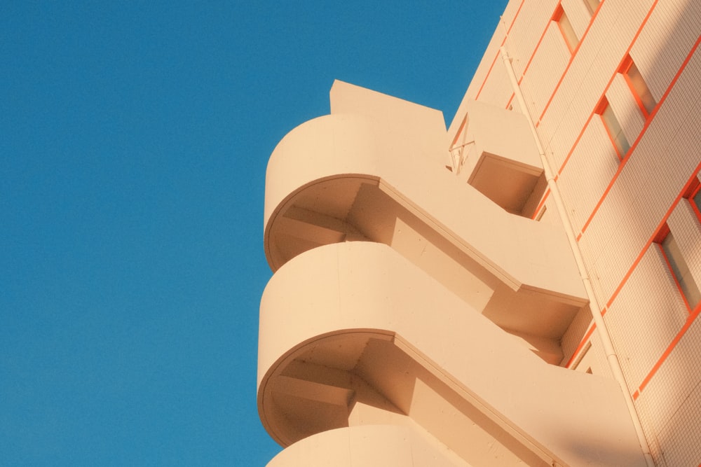 a tall white building with red trim against a blue sky